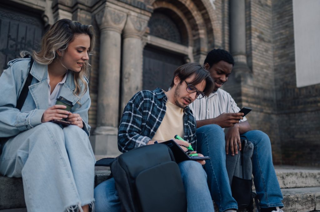 University students studying and relaxing on stairs of historic building